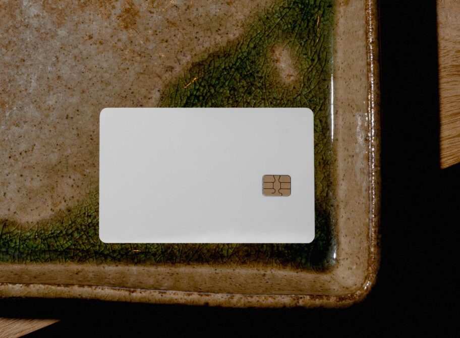 Blank credit card mockup on rusty metal tray with moss, overhead shot