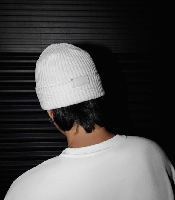 White ribbed beanie mockup with blank label patch on model from back view