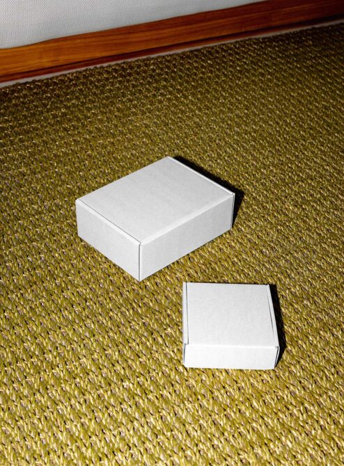 White box mockup on olive textured fabric with wood trim, closed box plus open flat layout