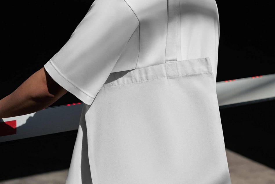 Close-up of white sport shorts on model with black background, showing seam details