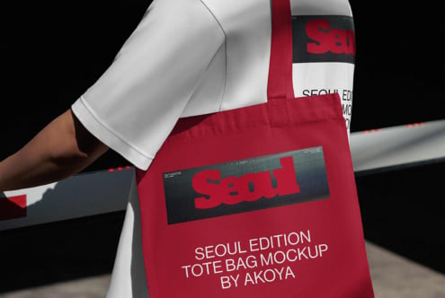 Red tote bag mockup with bold branding on dark label, worn over white sleeve