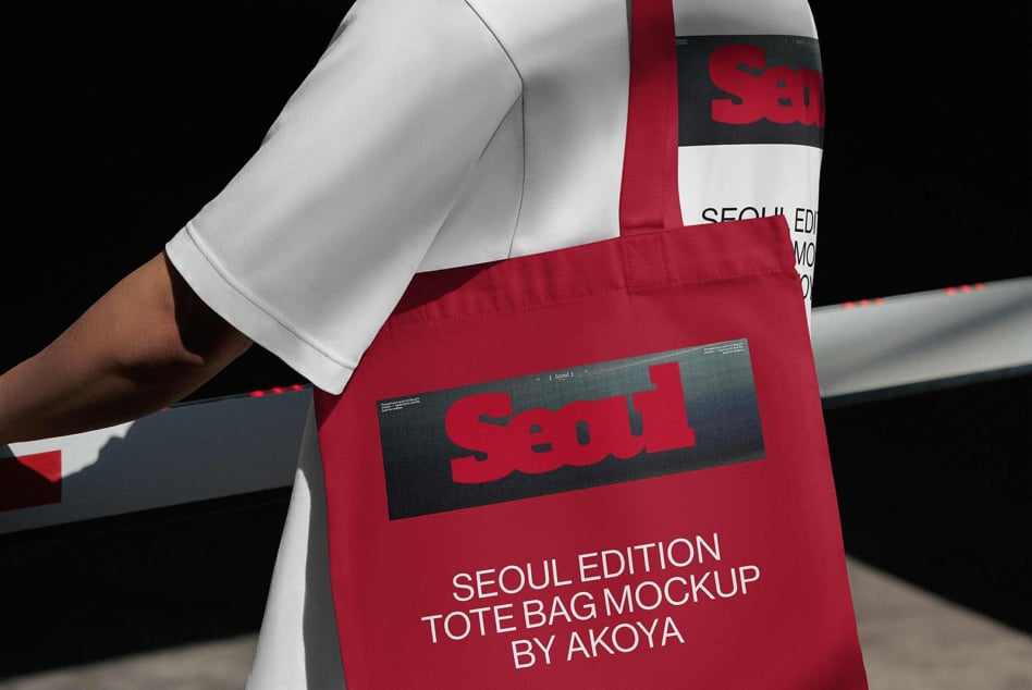 Red tote bag mockup with bold branding on dark label, worn over white sleeve