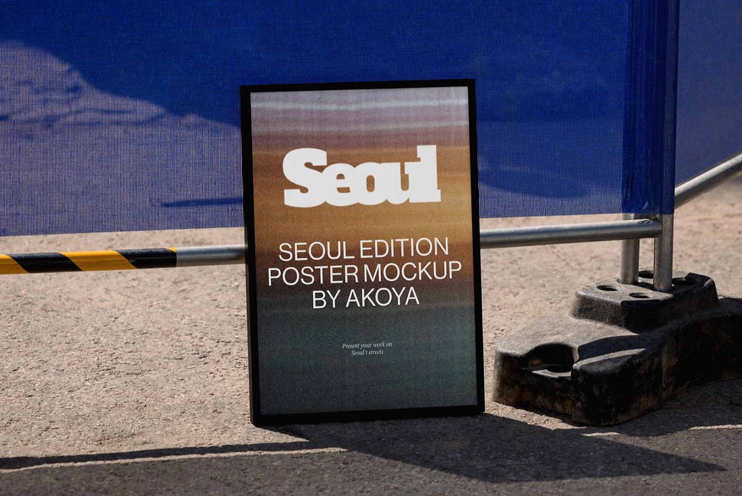 Framed poster leaning against blue wall on gritty Seoul street with metal railing