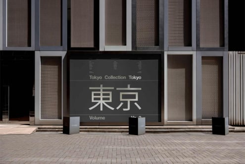 Storefront display with Tokyo Collection signage in Japanese characters on modern building facade with mesh panels