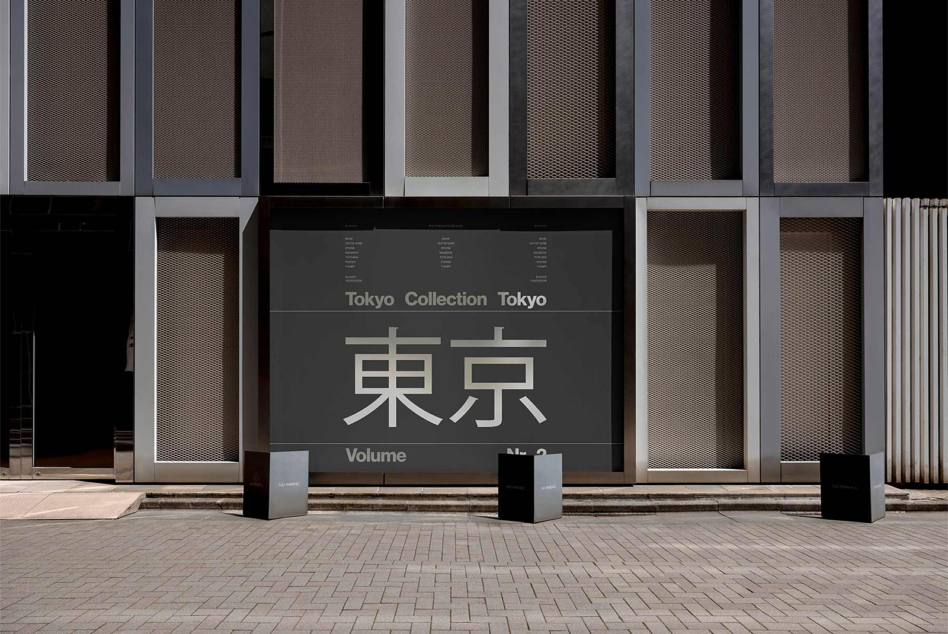 Storefront display with Tokyo Collection signage in Japanese characters on modern building facade with mesh panels