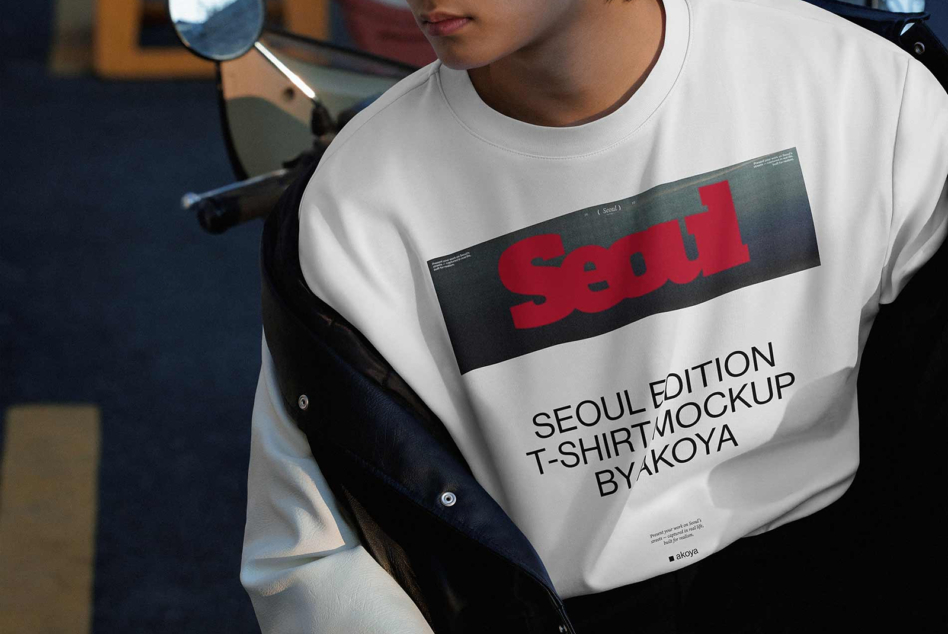 Guy wearing white tee with bold red graphic print over black box, Seoul Edition mockup