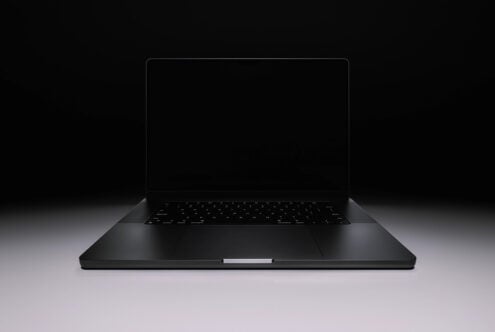 Sleek black laptop mockup with blank screen on dark background, angled view