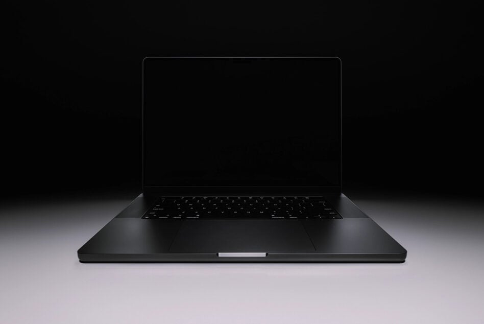 Sleek black laptop mockup with blank screen on dark background, angled view