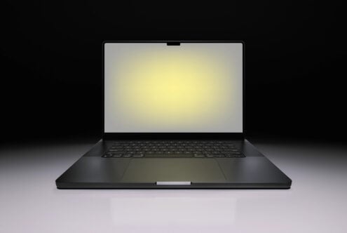 Black laptop mockup with glowing screen on dark background