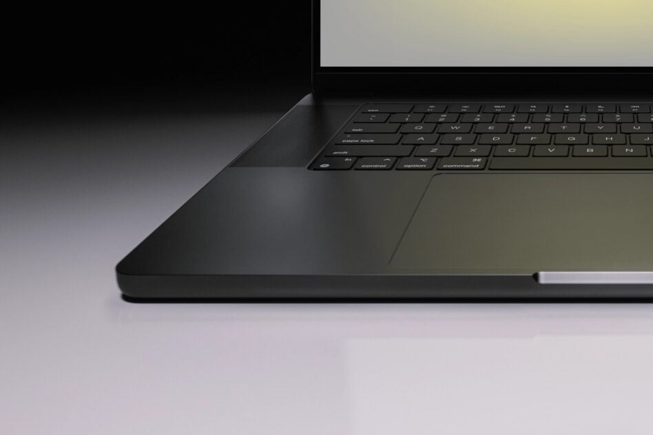 Sleek MacBook Pro shot from side angle showing keyboard, trackpad, with blank screen ready for your design
