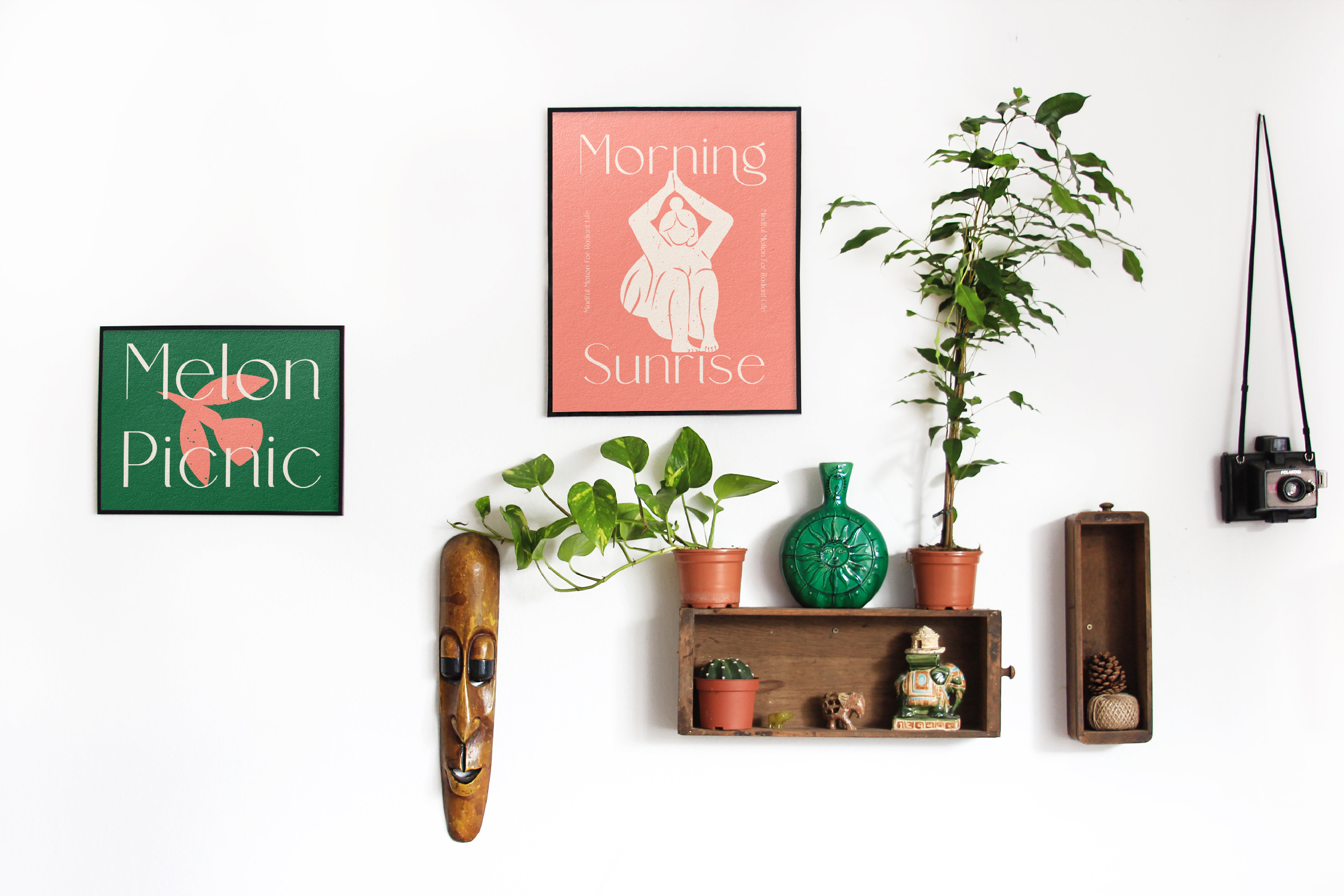 Styled wall shelf scene with green posters, potted plants, wooden mask, vintage camera