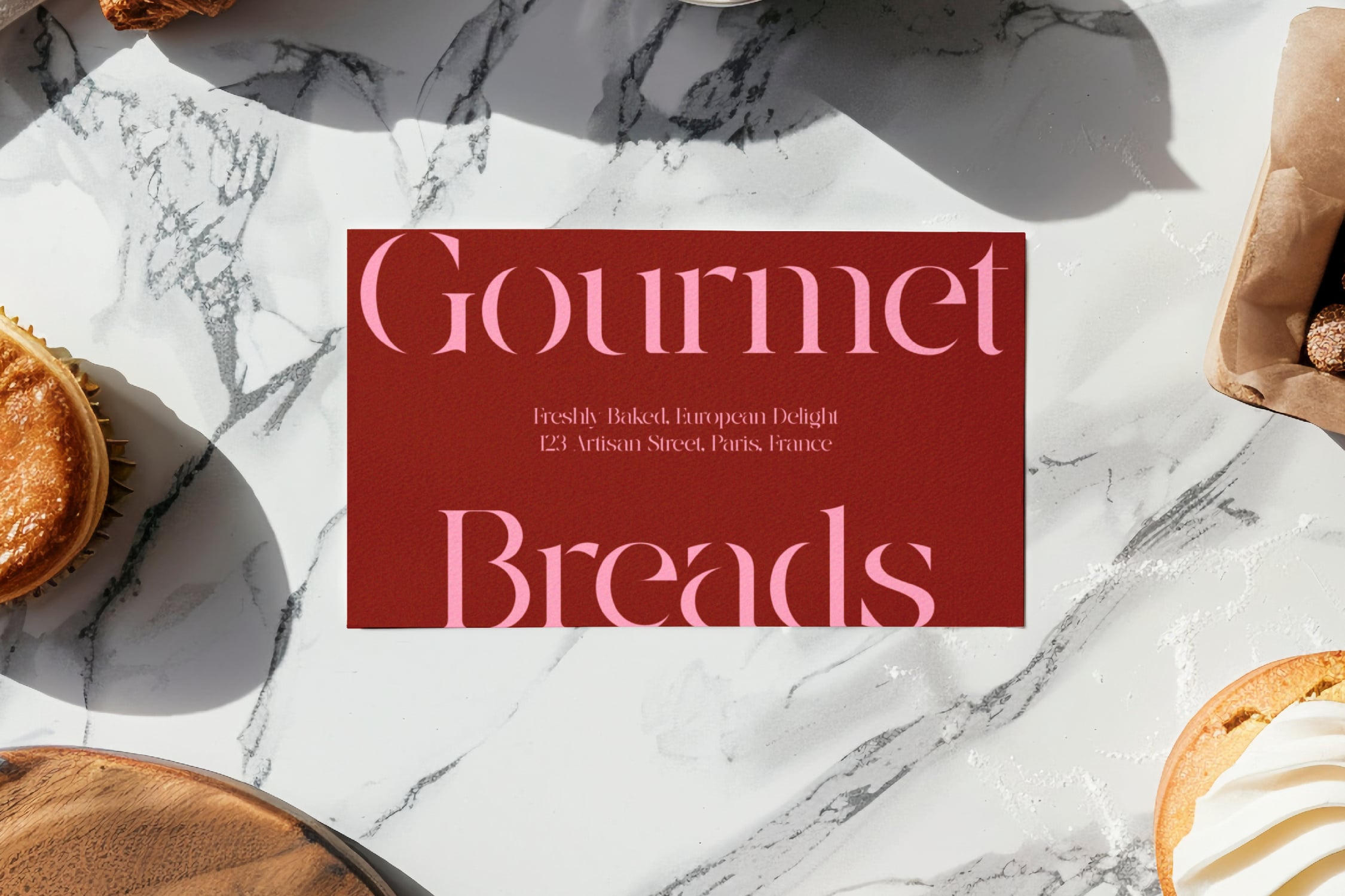 Gourmet Breads business card mockup on marble with fresh pastries styled around it