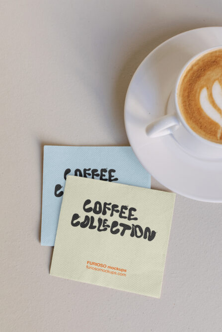 Overhead shot of cream notepad with "COFFEE COLLECTION" text next to latte in white cup on beige surface