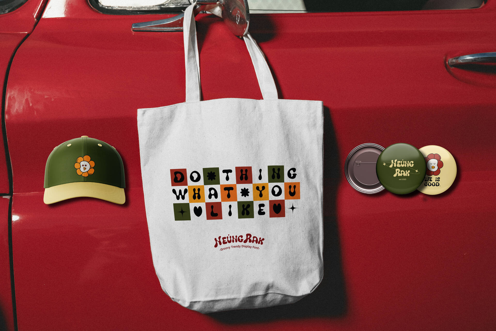 White tote bag with retro mosaic text design hanging on red vintage car door