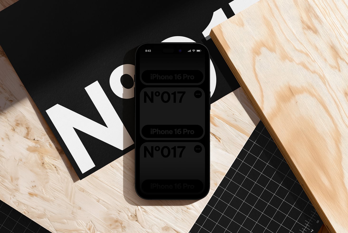 iPhone 16 Pro mockup surrounded by design materials on wood desk with geometric layouts