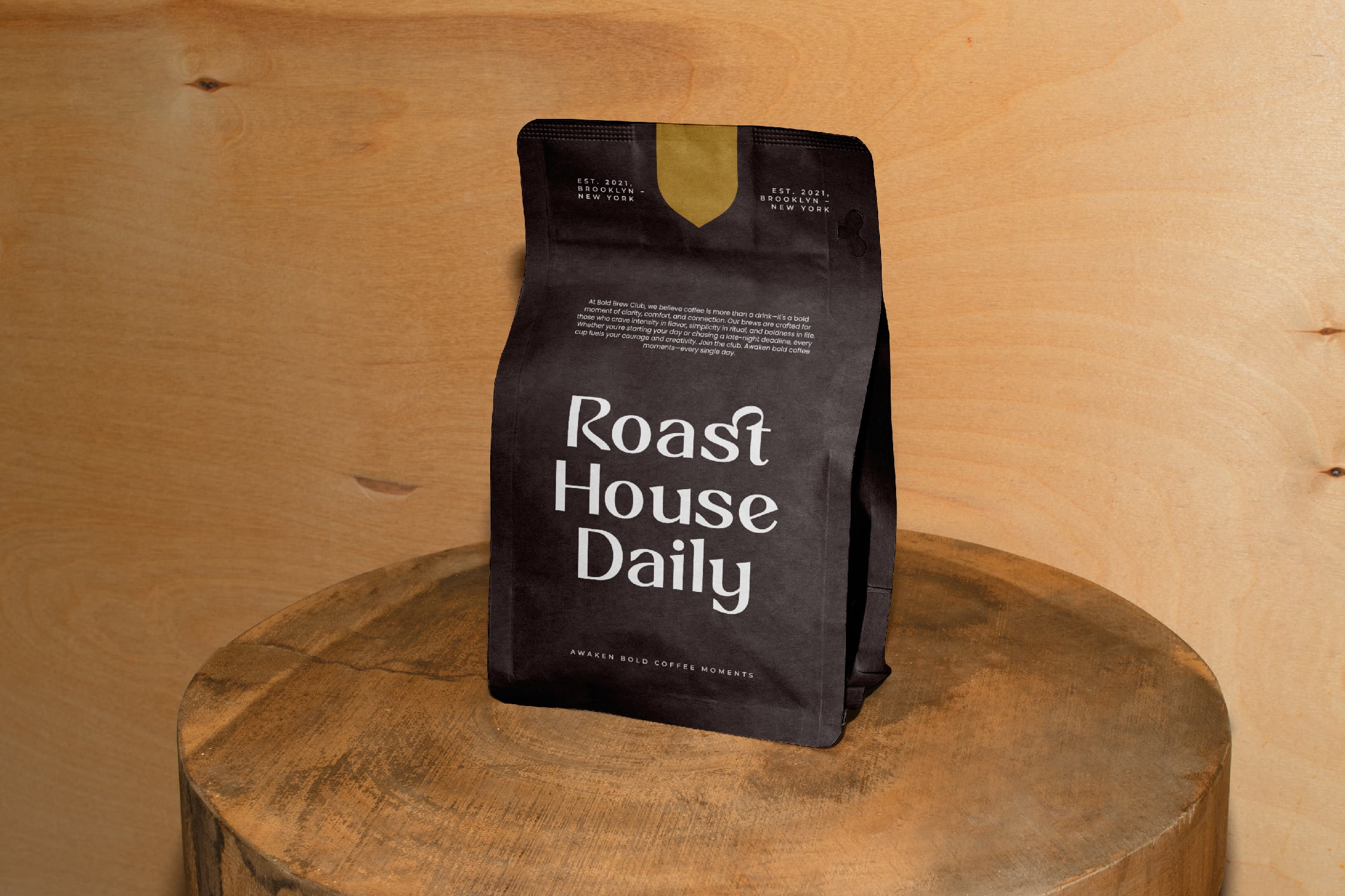 Black coffee bag with gold foil accent on wooden table against warm wood backdrop