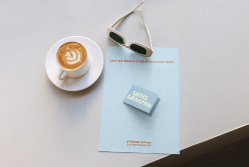 Flat lay of business card mockup on light blue poster next to latte with latte art, cream sunglasses on neutral background