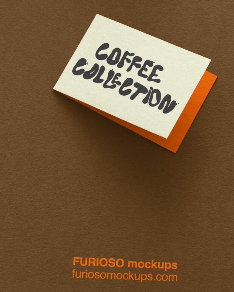 Cream card with "coffee collection" handwritten in dark ink, orange backing, angled on tan surface