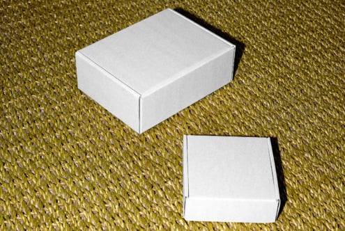 White box mockup on textured gold background with open lid below