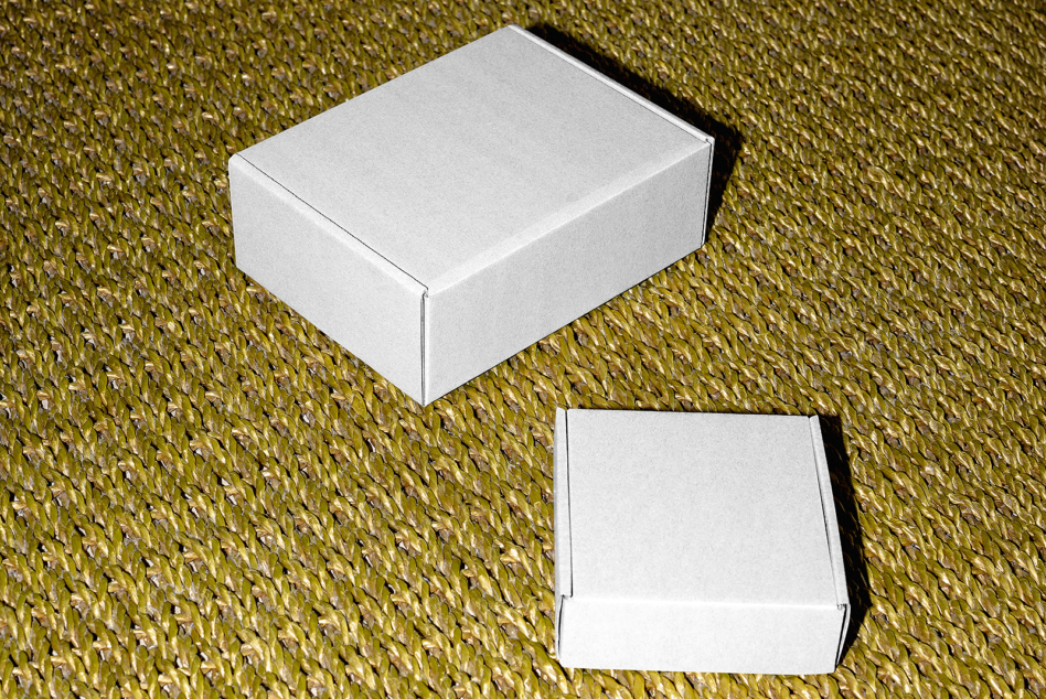 White box mockup on textured gold background with open lid below