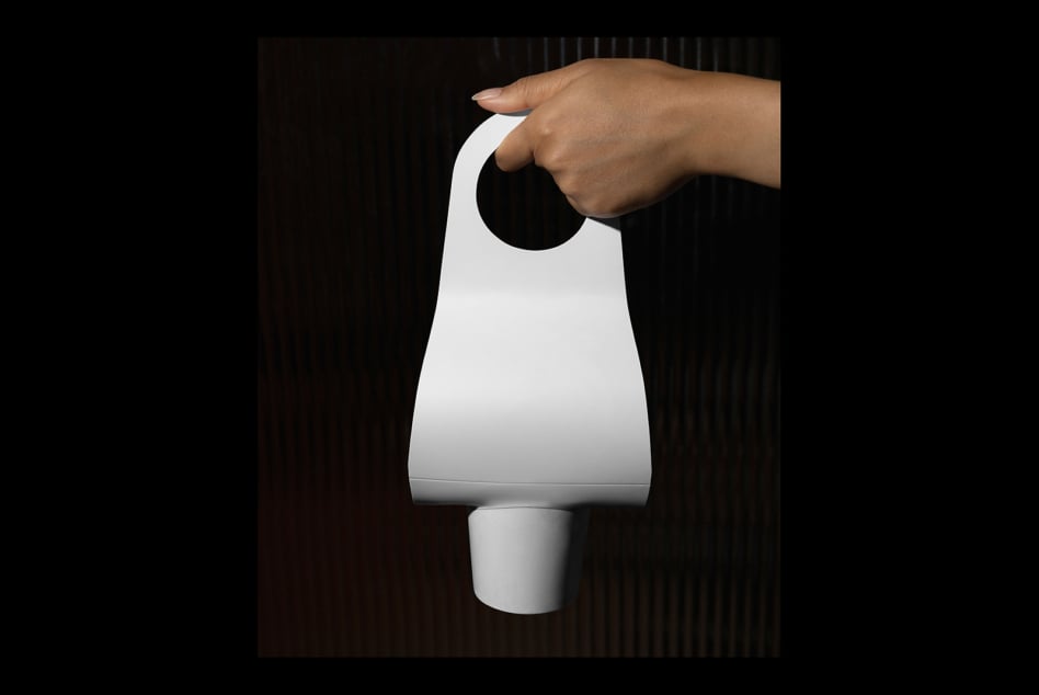 Hand holding white door hanger tag mockup against dark striped background