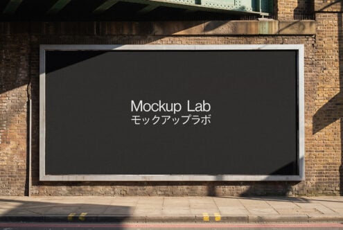 Outdoor billboard mockup with white frame on brick wall, text display in sunlight