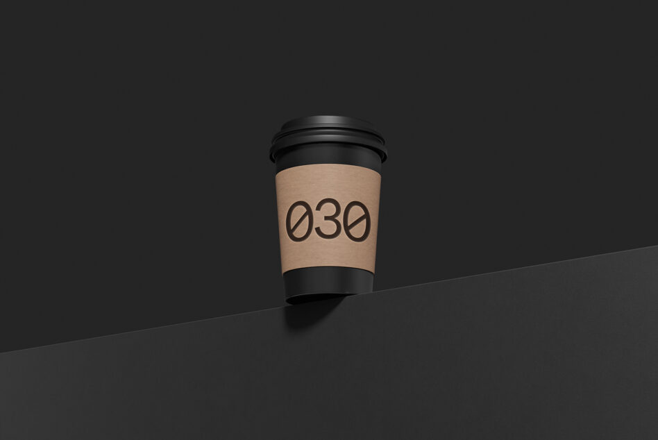 Minimalist coffee cup mockup with kraft sleeve showing "030" number on dark background