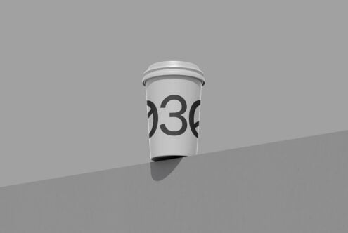 Minimalist coffee cup mockup with large numbers on white cup, casting shadow on gray surface