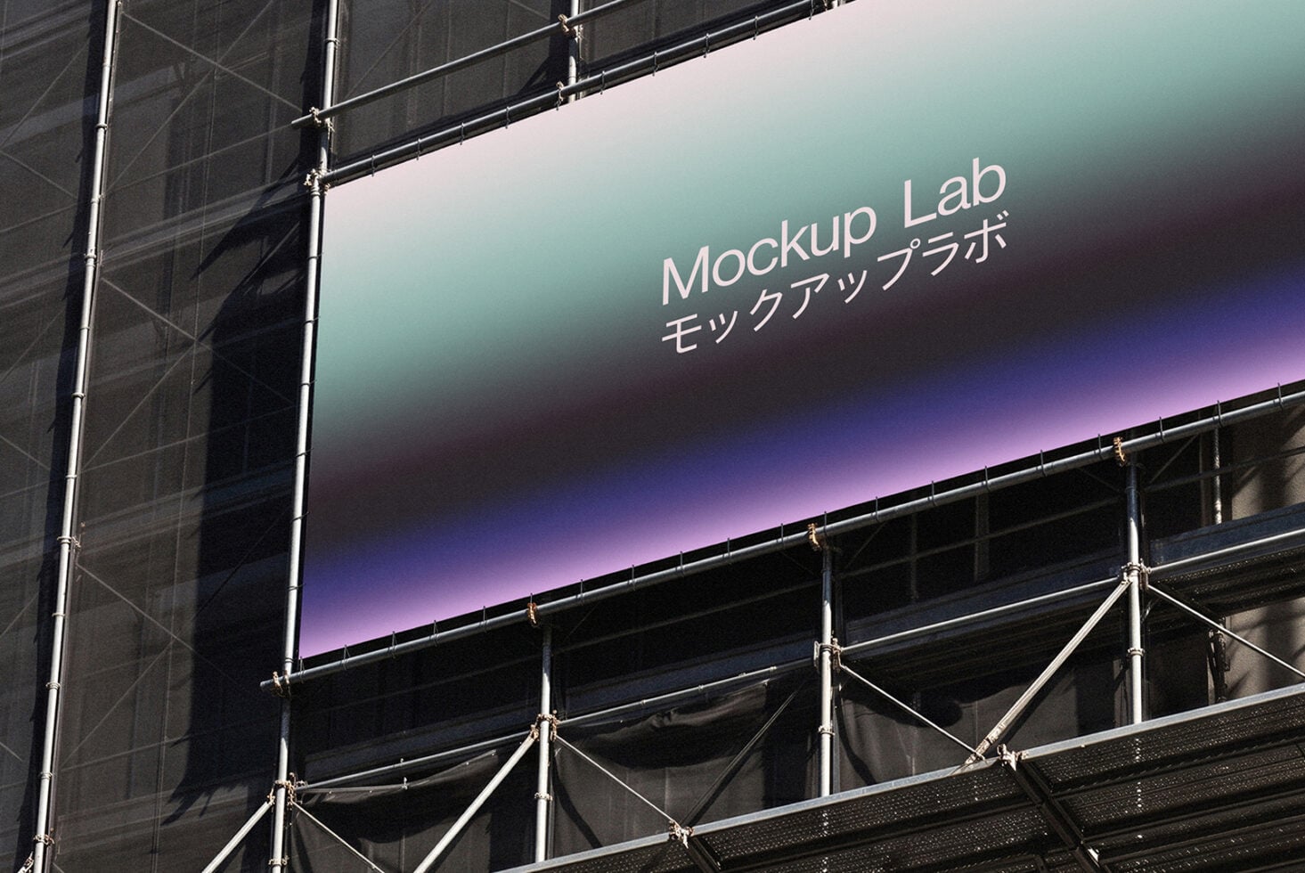Large construction site billboard with gradient screen displaying Mockup Lab text in English with Japanese characters below
