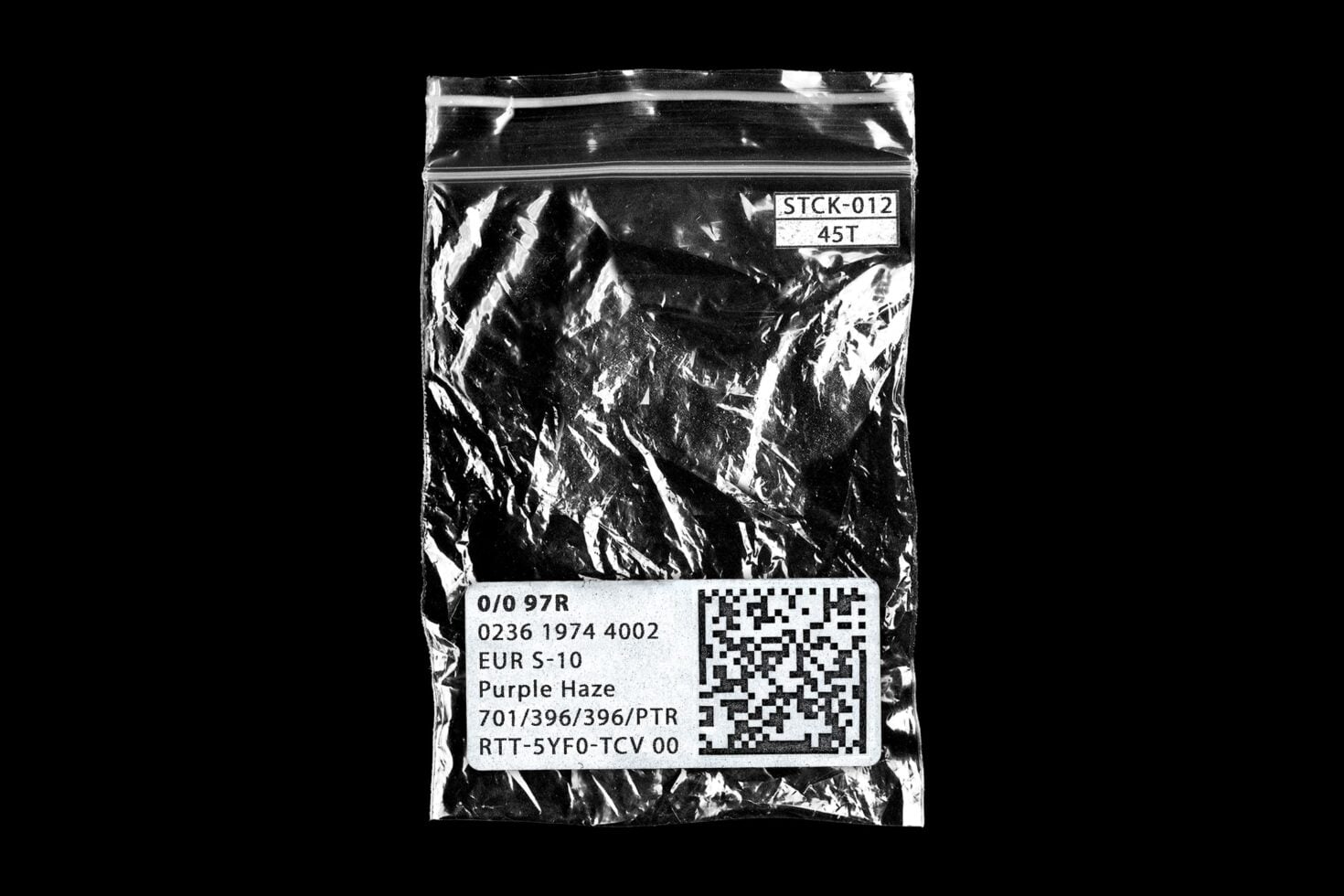 Crinkled plastic zip bag with product label, barcode, size tag against black background