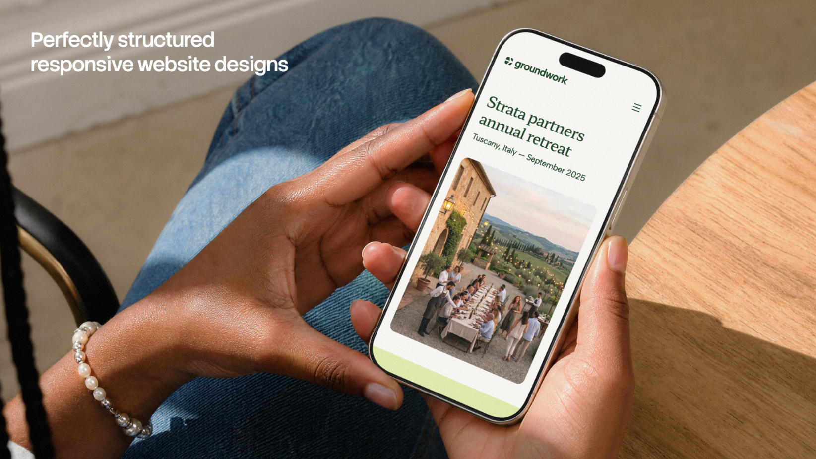 Hands holding phone displaying Groundwork website with Tuscany retreat event details