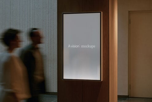 Framed display screen in modern hallway with blurred people walking by, wood paneling