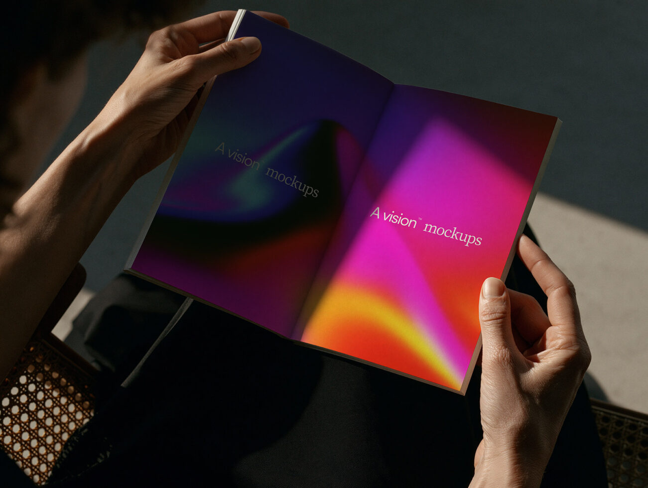 Hands holding open magazine with vibrant gradient from magenta to yellow, text reads A vision mockups