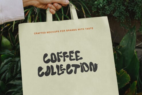 Hand holding natural canvas tote bag with Coffee Collection text in lush garden setting