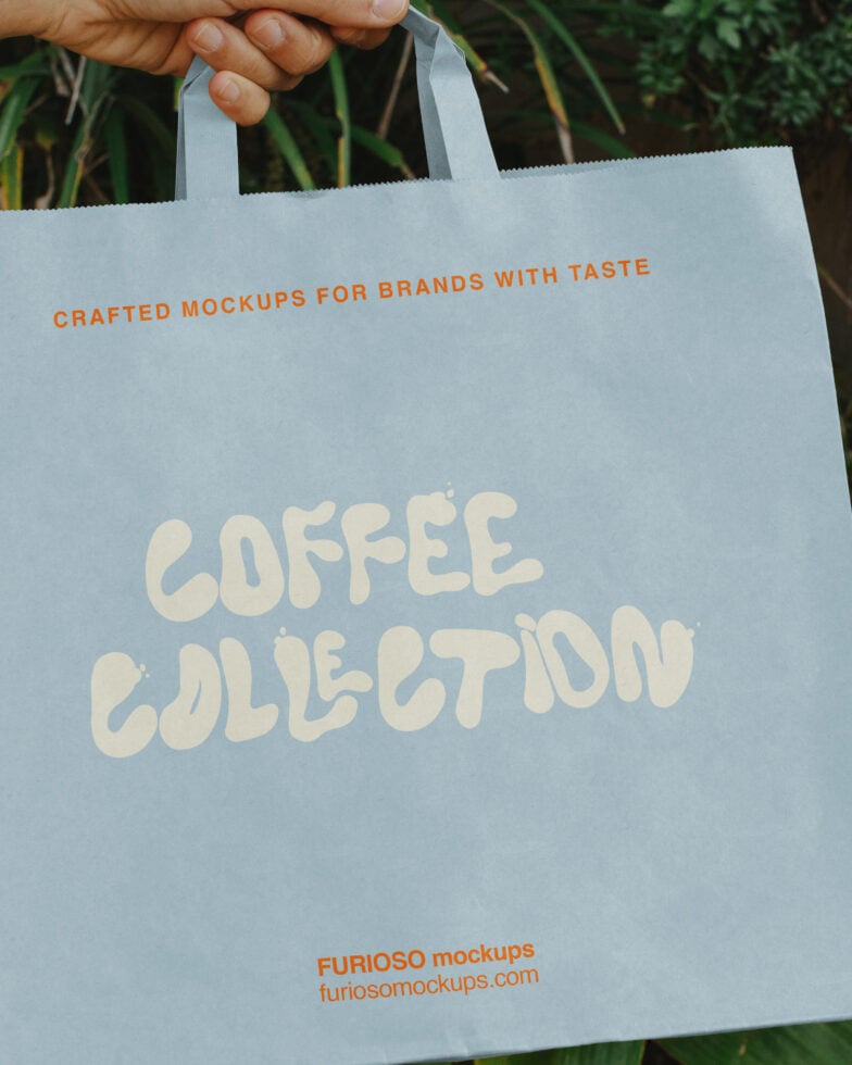 Hand holding light blue tote bag with "Coffee Collection" text mockup in cream lettering