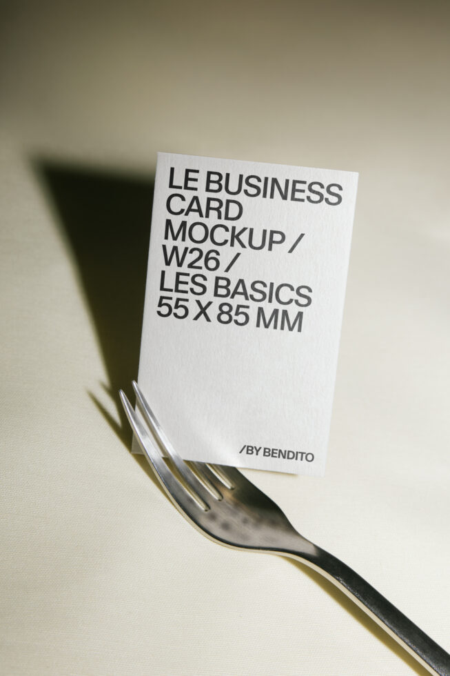 Minimal business card mockup balanced on fork with sharp shadow cast on neutral background