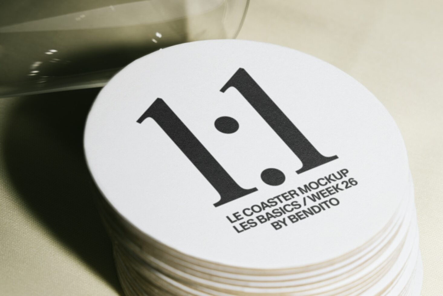 Stack of white coasters with bold black serif letter I logo printed on top surface