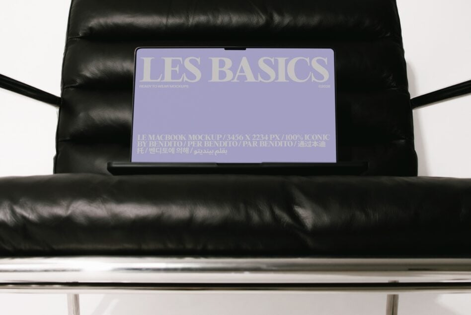 MacBook mockup on black leather couch showing Les Basics purple screen design with multilingual text