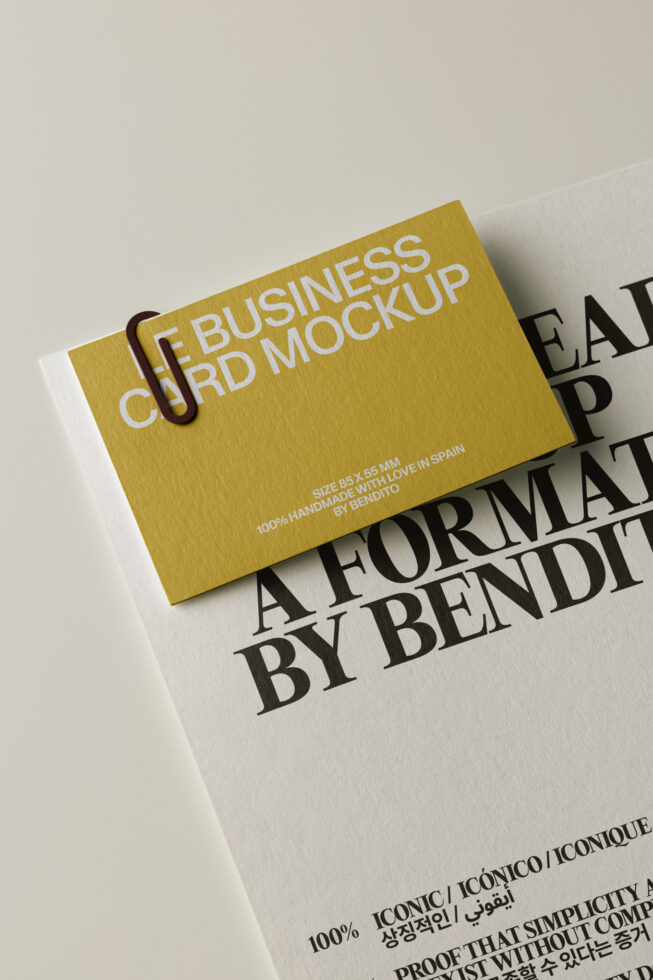 Gold business card mockup with paper clip, angled on textured background showing handmade details