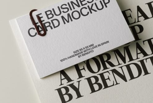 Minimal business card mockup with embossed text on white cardstock, brown paper clip detail visible