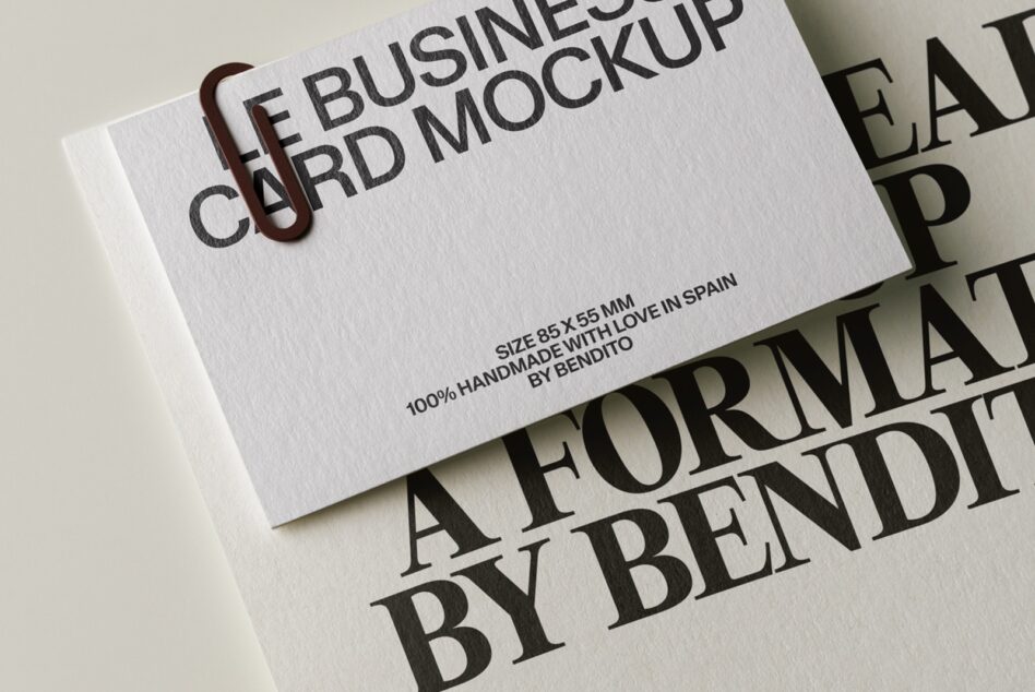 Minimal business card mockup with embossed text on white cardstock, brown paper clip detail visible