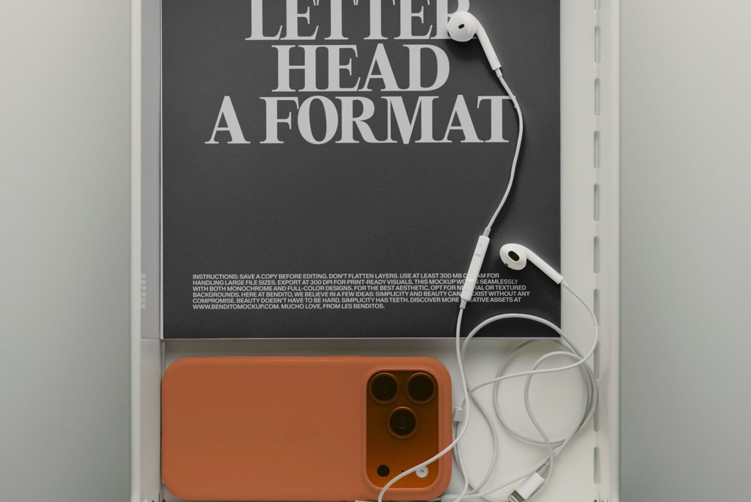Tablet with bold typography mockup featuring white earbuds on dark background next to orange phone case