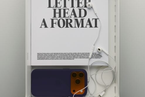 Flat lay letterhead mockup with navy phone, white earbuds, minimal desk setup