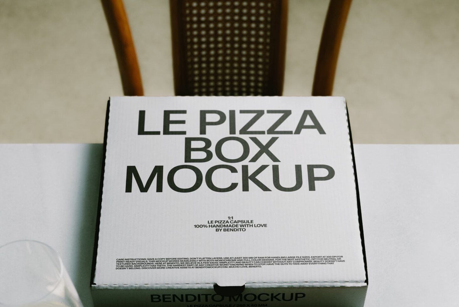 White pizza box mockup with bold typography on natural background with wooden chair