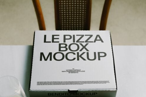 White pizza box mockup with bold typography on natural background with wooden chair