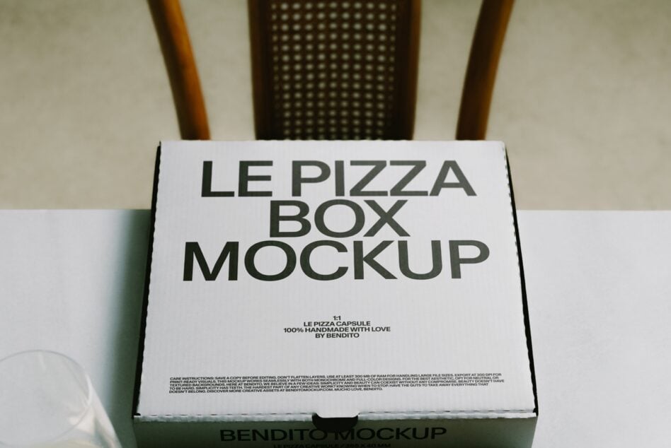 White pizza box mockup with bold typography on natural background with wooden chair