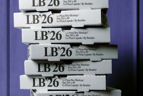 Stacked pizza boxes mockup showing white corrugated boxes with dark text labels against purple backdrop