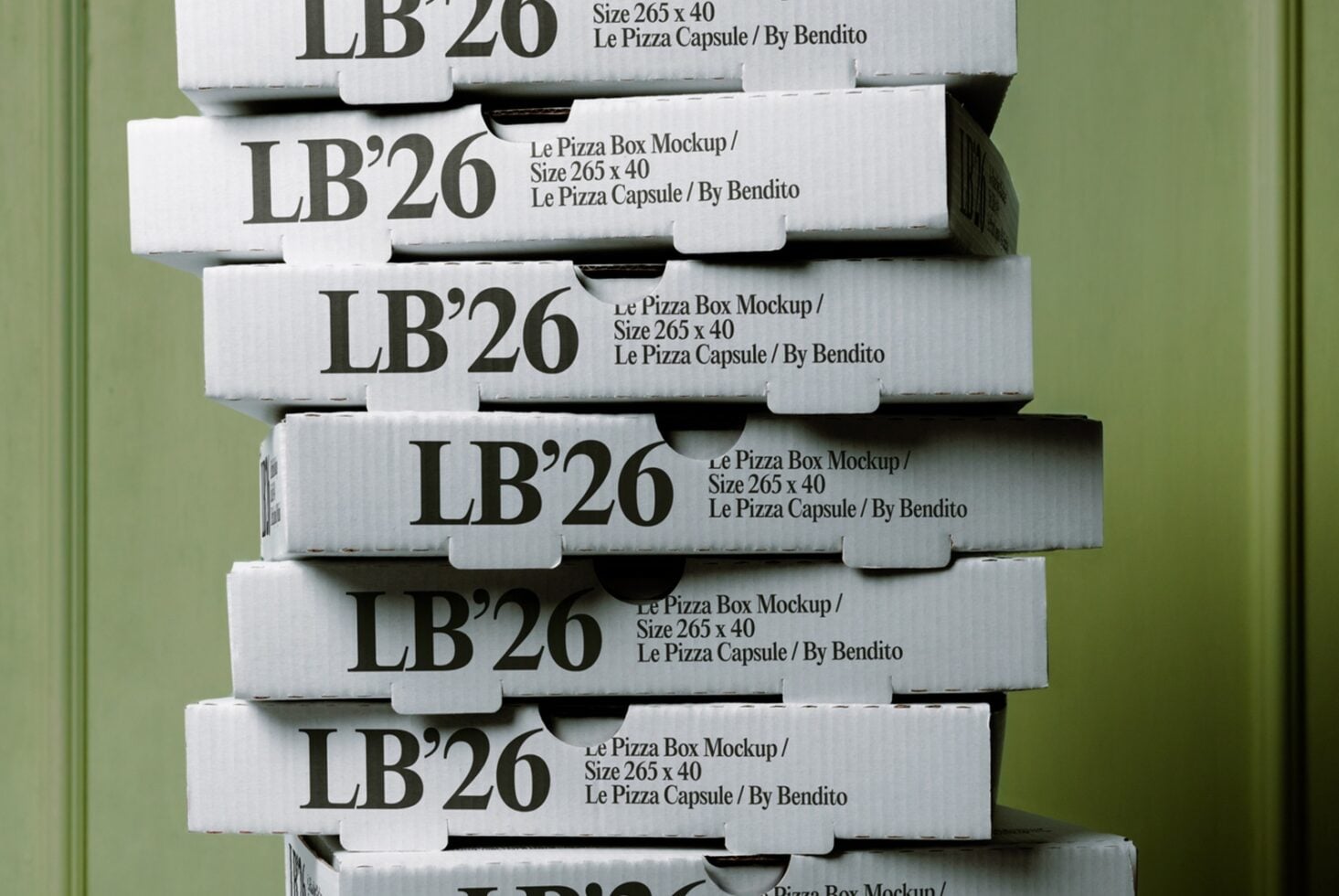 Stacked white pizza boxes with bold serif typography against soft green background