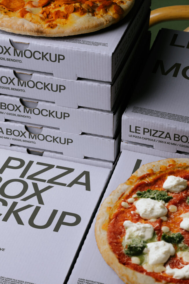 Stacked pizza boxes with fresh pies on top, one with pepperoni, one with mozzarella tomato