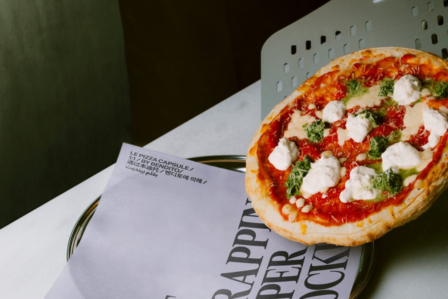 Fresh margherita pizza on multilingual menu with green backdrop, food styling mockup
